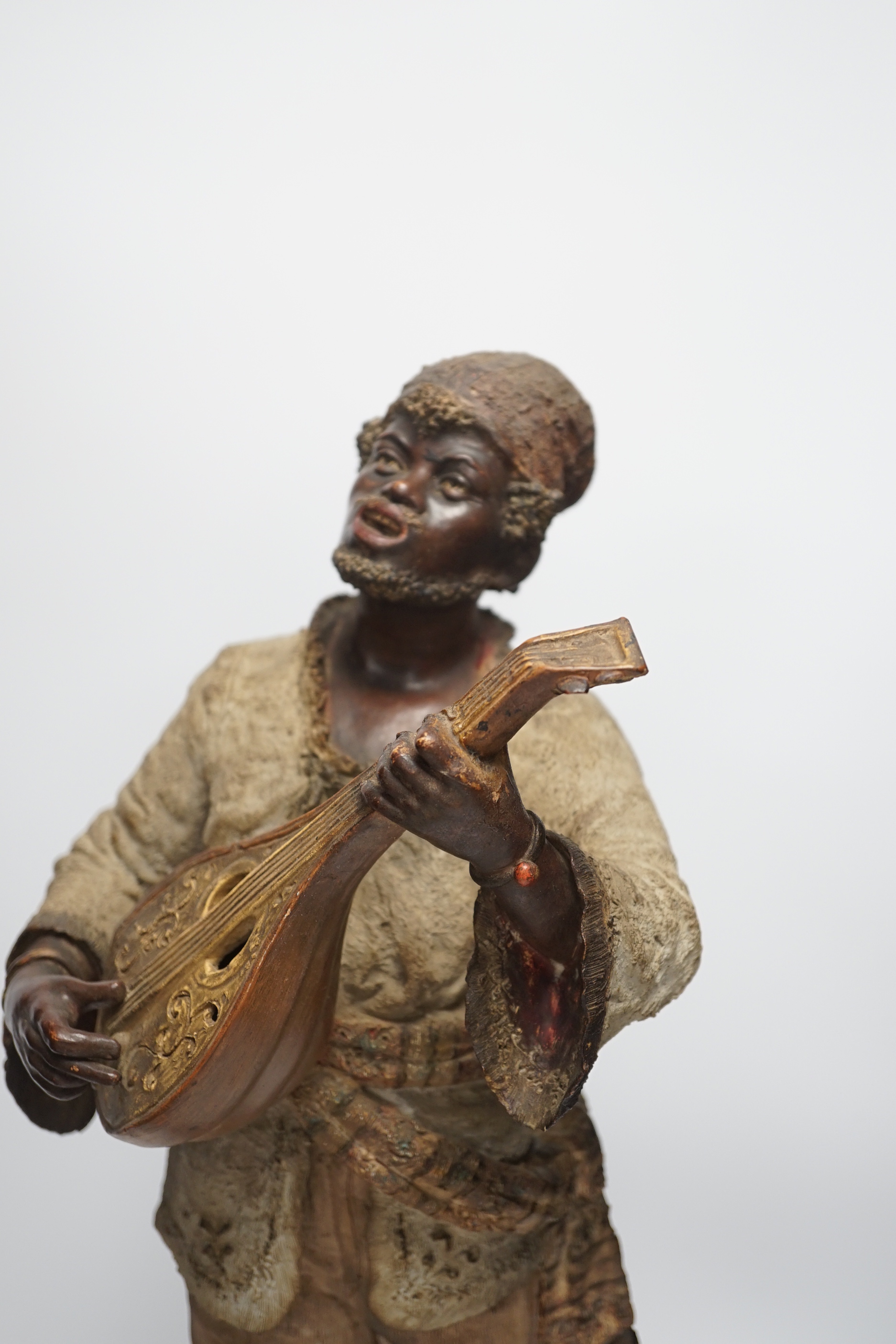 A pair of late 19th century Continental cold painted terracotta Nubian musician figures, 49cm